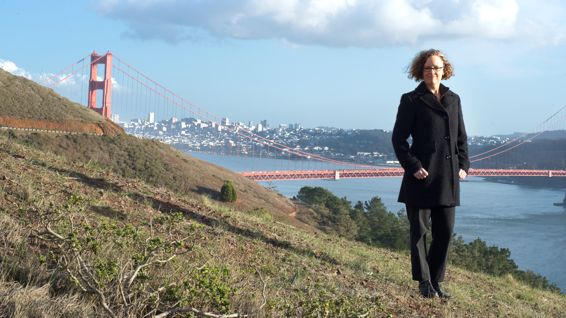 Indi Young standing on a hill with the Golden Gate Bridge in the background